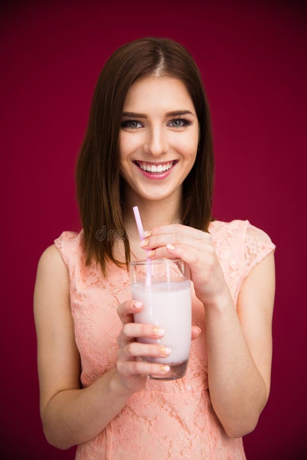 Mujer sonriente que se sostiene de cristal con el yogur fotografía de archivo Mujer sonriente que se sostiene de cristal con el yogur fotografía de archivo