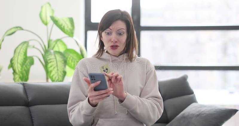 Mujer sorprendida con tarjeta de crédito y smartphone impactados por comprar metrajes