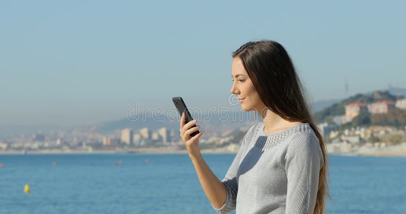 Mujer sorprendida en el teléfono en la playa