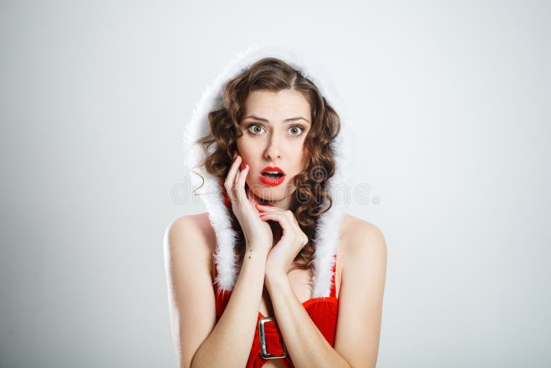 Mujer sorprendida hermosa que lleva la ropa de Papá Noel fotografía de archivo Mujer sorprendida hermosa que lleva la ropa de Papá Noel fotografía de archivo