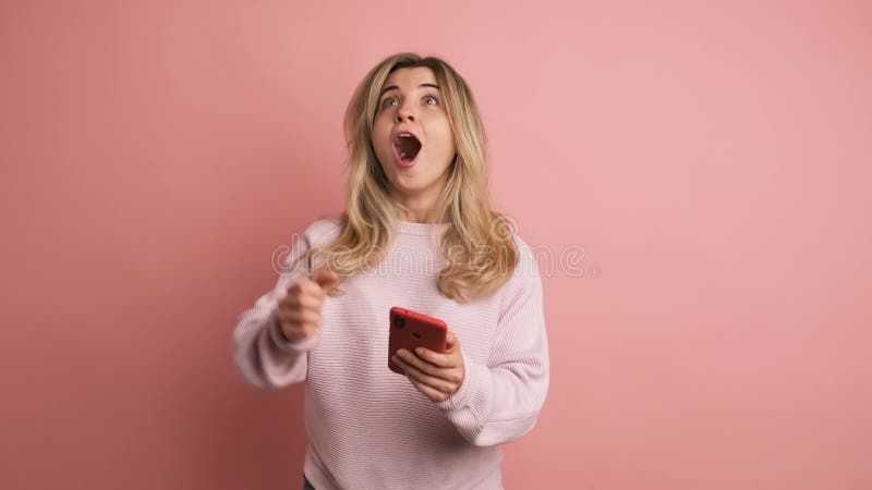 Mujer sorprendida mirando la pantalla de un móvil metrajes