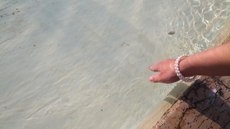 Mujer sosteniendo la mano con una pulsera de perlas en el metrajes