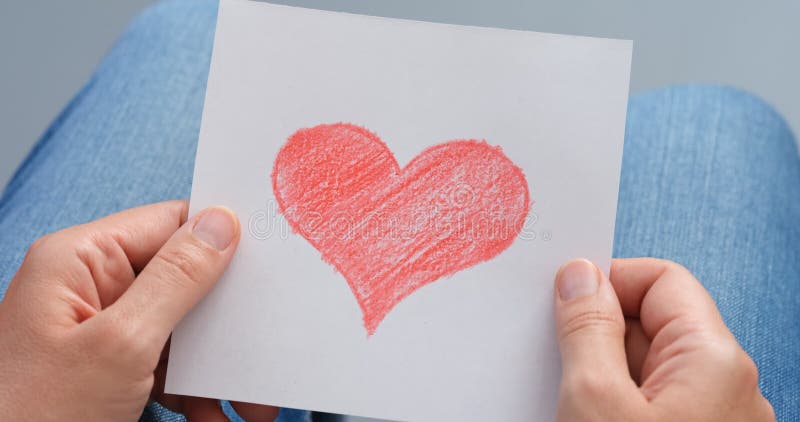 Mujer sosteniendo una imagen dibujada a mano con el corazón en las manos. almacen de metraje de vídeo