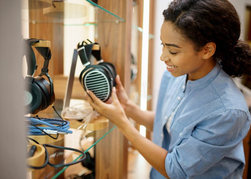 Mujer Sostiene Auriculares En La Tienda De Componentes De Audio Imagen de  archivo - Imagen de fondo, almacén: 205334319