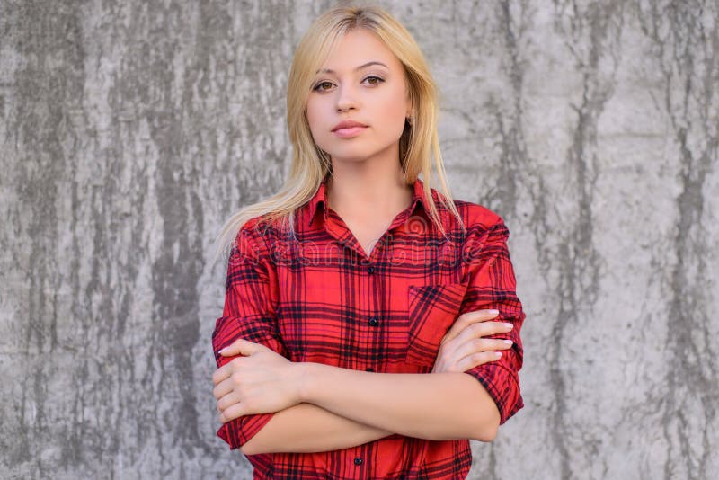 Mujer tranquila confiada con los brazos cruzados, mirando la cámara Chica joven hermosa en la camisa roja a cuadros que se opone fotografía de archivo Mujer tranquila confiada con los brazos cruzados, mirando la cámara Chica joven hermosa en la camisa roja a cuadros que se opone fotografía de archivo