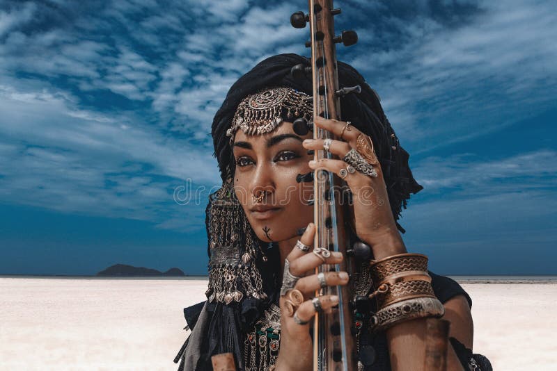 Mujer tribal elegante joven hermosa en el traje oriental que juega el sitar al aire libre Cierre para arriba imagen de archivo libre de regalías