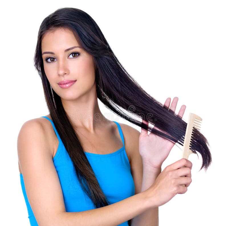 Young pretty brunette woman combing her beautiful long hair - isoalted on white background. Young pretty brunette woman combing her beautiful long hair - isoalted on white background