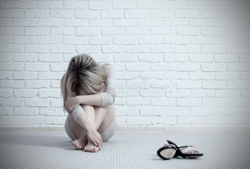 Mujer triste joven que se sienta en el piso y el griterío fotos de archivo Mujer triste joven que se sienta en el piso y el griterío fotos de archivo