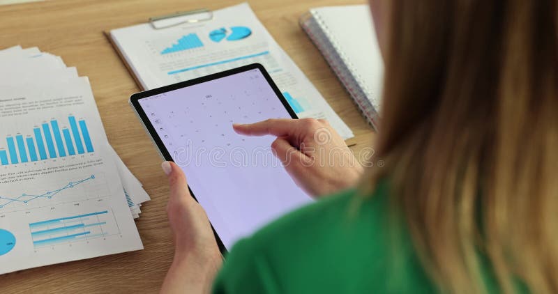 Mujer usa aplicación de calendario en el tablet en el cargo almacen de metraje de vídeo