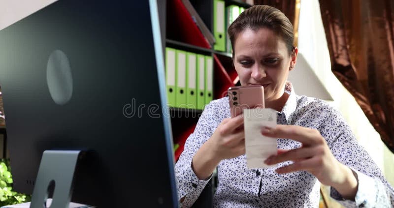 Mujer usa smartphone para escanear código de barras y pagar un teléfono mensual almacen de video