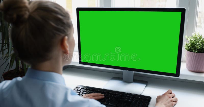 Mujer usando computadora de escritorio en la oficina desplazándose mouse. maqueta con pantalla verde en blanco