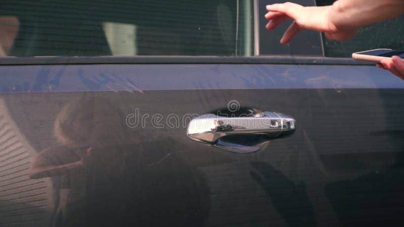 Mujer utiliza servicios de uso compartido de coches abre un coche utilizando una aplicación móvil almacen de video