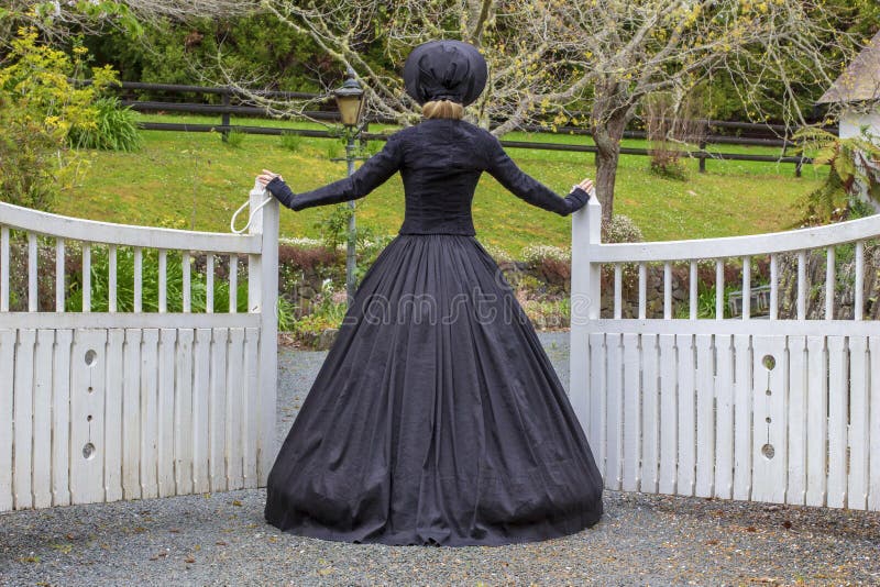 Mujer victoriana en jardín y la apertura del verano de una puerta imágenes de archivo libres de regalías Mujer victoriana en jardín y la apertura del verano de una puerta imágenes de archivo libres de regalías