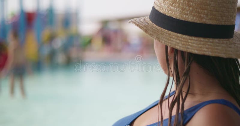 Mujer viendo a los niños en el parque acuático almacen de metraje de vídeo