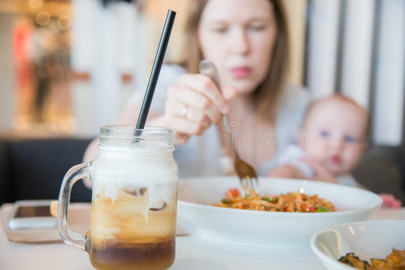 Mujer y su bebé en un café imagen de archivo Mujer y su bebé en un café imagen de archivo