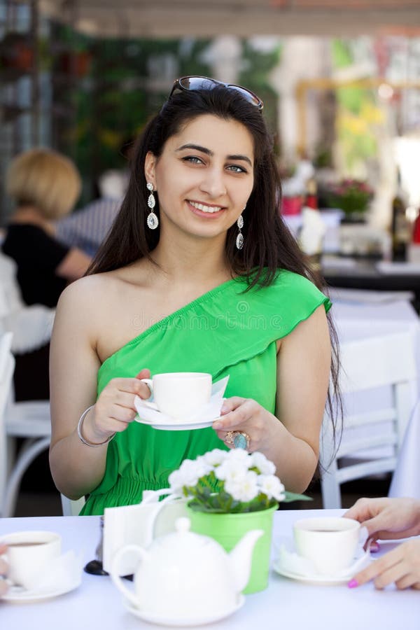 Mujer árabe bastante joven que se sienta en el café fotografía de archivo Mujer árabe bastante joven que se sienta en el café fotografía de archivo