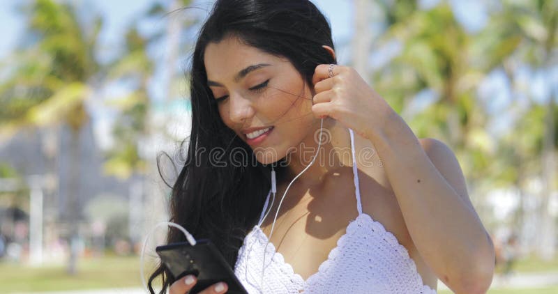 Mujer étnica bonita que usa el teléfono afuera