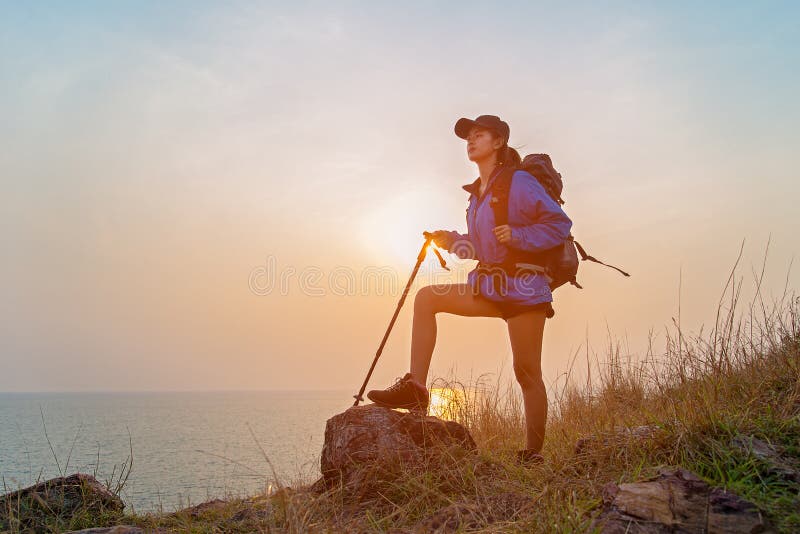 Mujeres acertadas del caminante que caminan con la mochila que se coloca encima de la montaña y que disfruta de la opinión del va imagen de archivo Mujeres acertadas del caminante que caminan con la mochila que se coloca encima de la montaña y que disfruta de la opinión del va imagen de archivo