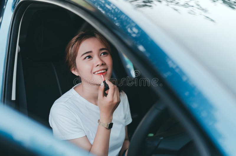 Mujeres asi?ticas hermosas que aplican maquillaje en coche interior foto de archivo Mujeres asi?ticas hermosas que aplican maquillaje en coche interior foto de archivo