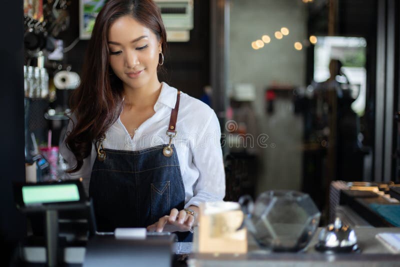 Mujeres asiáticas Barista que sonríe y que usa la máquina del café en contador de la cafetería - comida y bebida del propietario