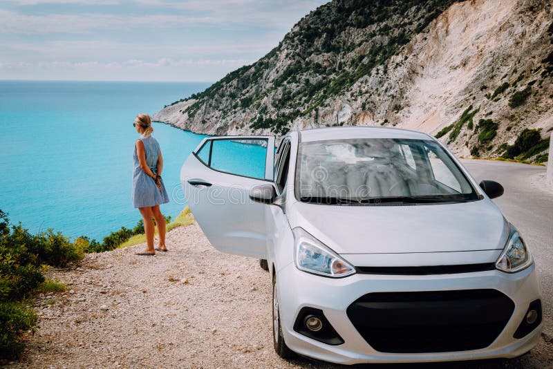 Mujeres cerca del coche alquilado con la puerta abierta que gozan de la playa de Myrtos concepto de la vocaci?n del viaje Kefalon fotos de archivo Mujeres cerca del coche alquilado con la puerta abierta que gozan de la playa de Myrtos concepto de la vocaci?n del viaje Kefalon fotos de archivo