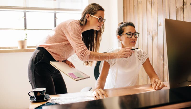 Mujeres de negocios creativas que trabajan en el ordenador fotografía de archivo libre de regalías Mujeres de negocios creativas que trabajan en el ordenador fotografía de archivo libre de regalías