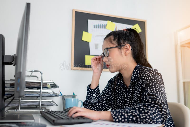 Mujeres De Negocios Tocan Sus Lentes Mientras Trabajan En Una Computadora Oficina. Mujer Asiática Con Anteojos Mirando La Pa de archivo - Imagen de mirando, funcionamiento: 201118080