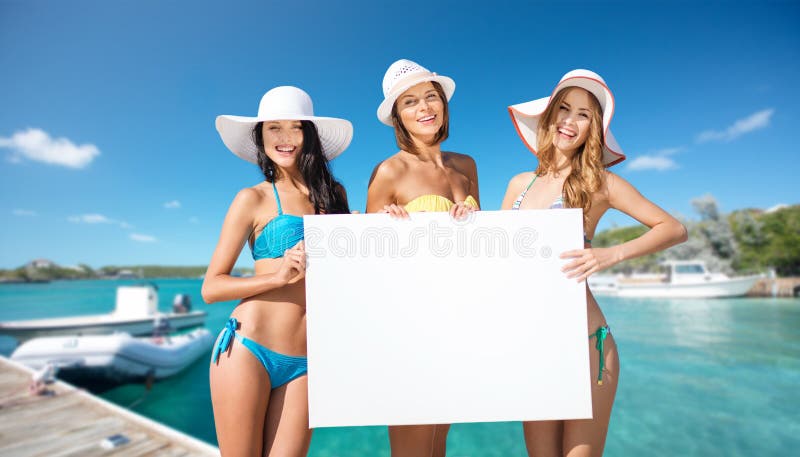 Mujeres en bikini con pizarra blanca en la playa imagen de archivo libre de regalías
