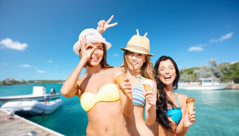 Mujeres felices en bikini con helado en la playa foto de archivo libre de regalías