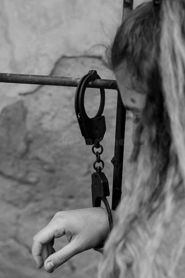 Mujeres jovenes cerradas con las esposas al radiador imagen de archivo libre de regalías Mujeres jovenes cerradas con las esposas al radiador imagen de archivo libre de regalías