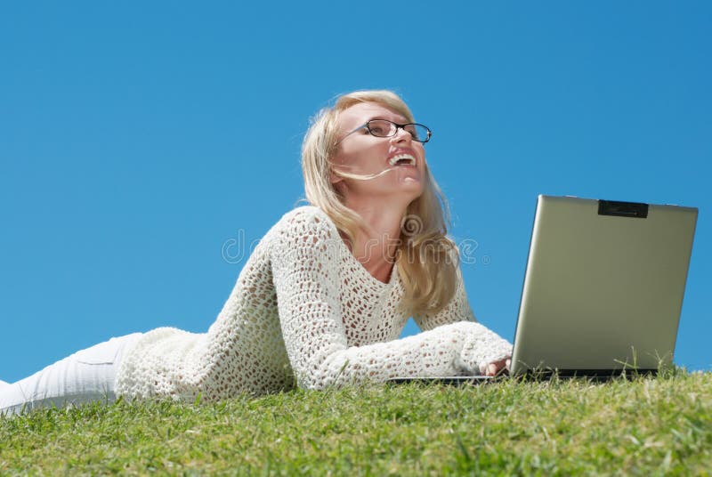 Mujeres jovenes felices que sonríen y que trabajan en una computadora portátil imagen de archivo libre de regalías Mujeres jovenes felices que sonríen y que trabajan en una computadora portátil imagen de archivo libre de regalías