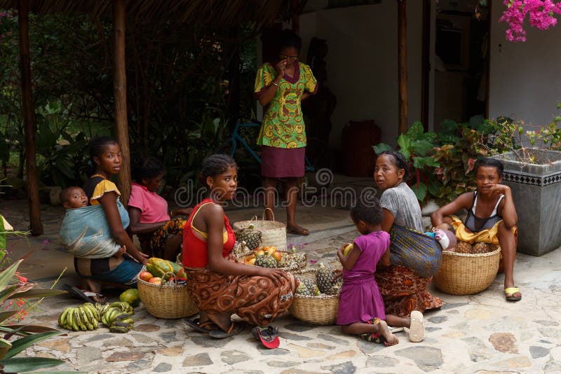 Mujeres malgaches que preparan la cesta de fruta para la venta del mercado callejero, imagen de archivo Mujeres malgaches que preparan la cesta de fruta para la venta del mercado callejero, imagen de archivo
