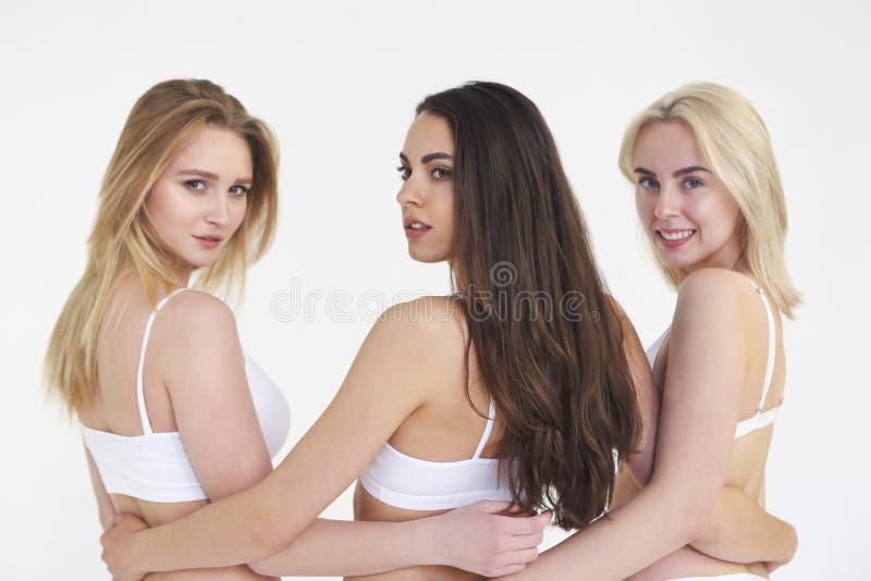 Mujeres multiétnicas jovenes alegres en la ropa interior blanca junto imágenes de archivo libres de regalías Mujeres multiétnicas jovenes alegres en la ropa interior blanca junto imágenes de archivo libres de regalías
