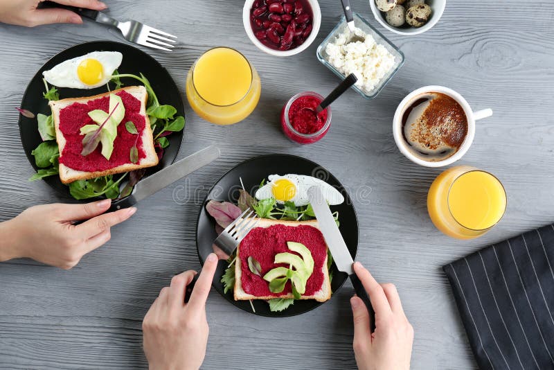 Mujeres que comen tostadas con goma y el aguacate de la remolacha fotografía de archivo libre de regalías Mujeres que comen tostadas con goma y el aguacate de la remolacha fotografía de archivo libre de regalías