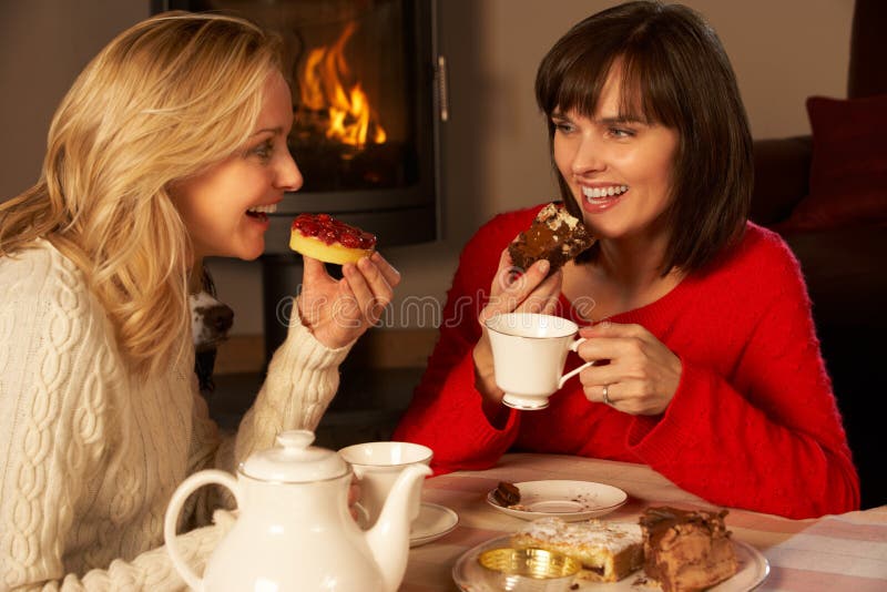 Mujeres que gozan de té y de la torta junto fotografía de archivo libre de regalías Mujeres que gozan de té y de la torta junto fotografía de archivo libre de regalías