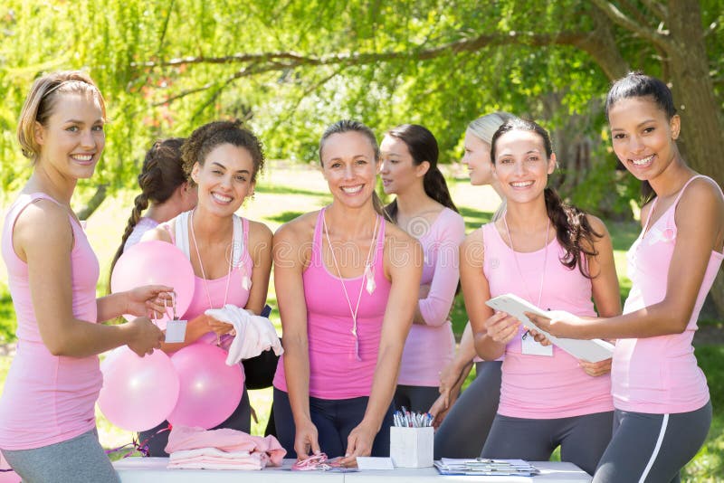 Smiling women organising event for breast cancer awareness on a sunny day. Smiling women organising event for breast cancer awareness on a sunny day