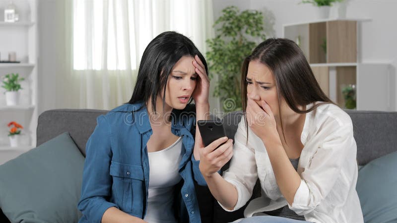 Mujeres tristes que leen malas noticias en el teléfono elegante