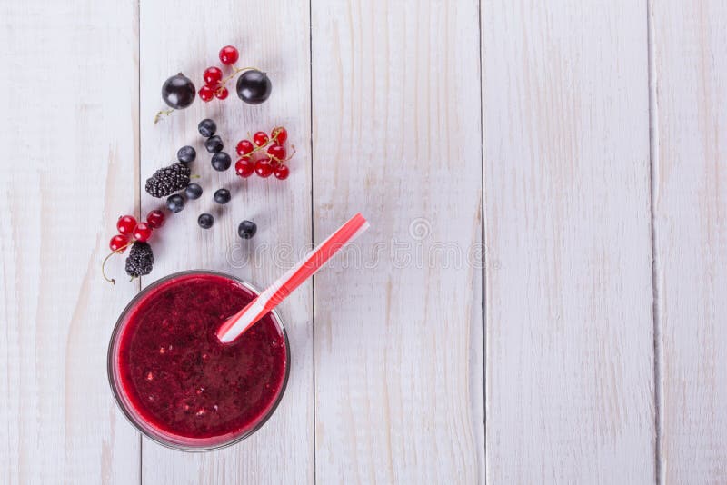 Mulberry berries, blackberries, currants and glass of smoothie on the wooden table. The flat composition stock images Mulberry berries, blackberries, currants and glass of smoothie on the wooden table. The flat composition stock images