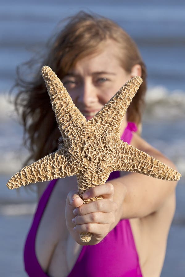 Mulher adulta nova que guarda uma estrela do mar fotos de stock royalty free Mulher adulta nova que guarda uma estrela do mar fotos de stock royalty free
