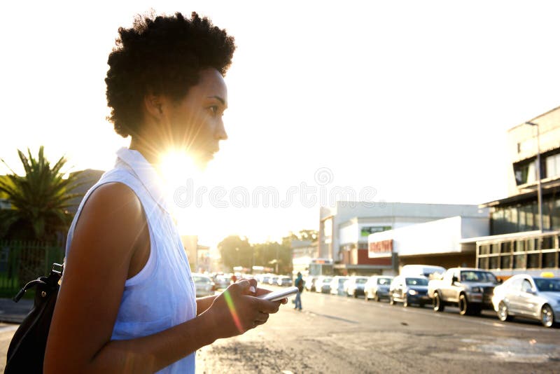 Mulher africana com telefone celular na rua da cidade fotos de stock Mulher africana com telefone celular na rua da cidade fotos de stock