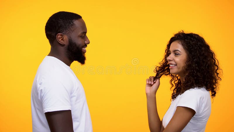 Mulher afro-americana brincalhão que flerta com homem negro, data romântica do convite fotografia de stock Mulher afro-americana brincalhão que flerta com homem negro, data romântica do convite fotografia de stock