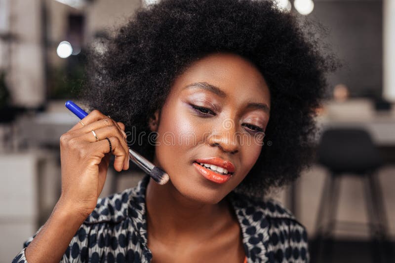 Mulher afro-americano bonita com o cabelo encaracolado que põe um ocultador novo sobre sua cara imagens de stock royalty free Mulher afro-americano bonita com o cabelo encaracolado que põe um ocultador novo sobre sua cara imagens de stock royalty free