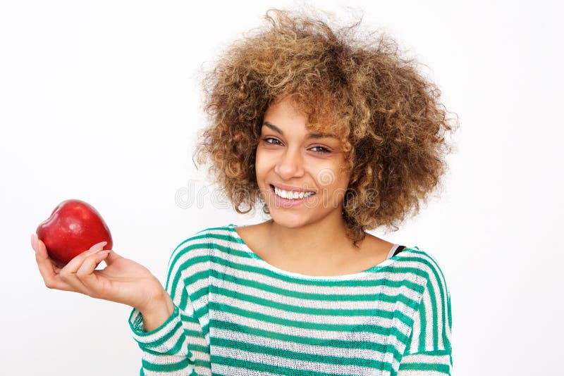 Mulher afro-americano nova atrativa que guarda uma maçã foto de stock Mulher afro-americano nova atrativa que guarda uma maçã foto de stock