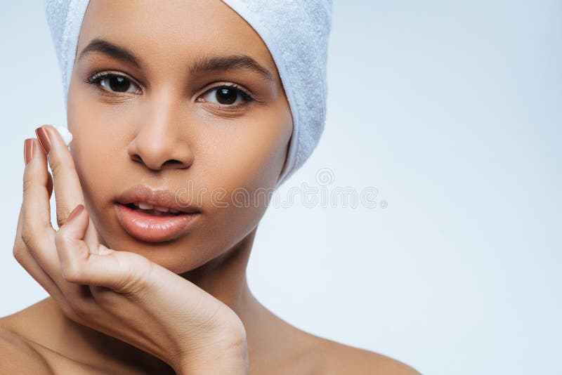Mulher agradável bonita que aplica o creme facial imagem de stock royalty free Mulher agradável bonita que aplica o creme facial imagem de stock royalty free