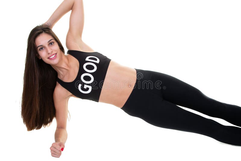A mulher alegre desportiva bonita est? fazendo o exerc?cio lateral da prancha fotos de stock A mulher alegre desportiva bonita est? fazendo o exerc?cio lateral da prancha fotos de stock