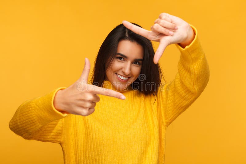 Mulher alegre que faz o quadro com mãos fotos de stock