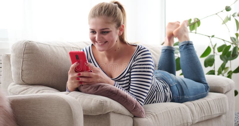 Mulher alegre que relaxa e que toma o selfie usando a câmera do telefone celular