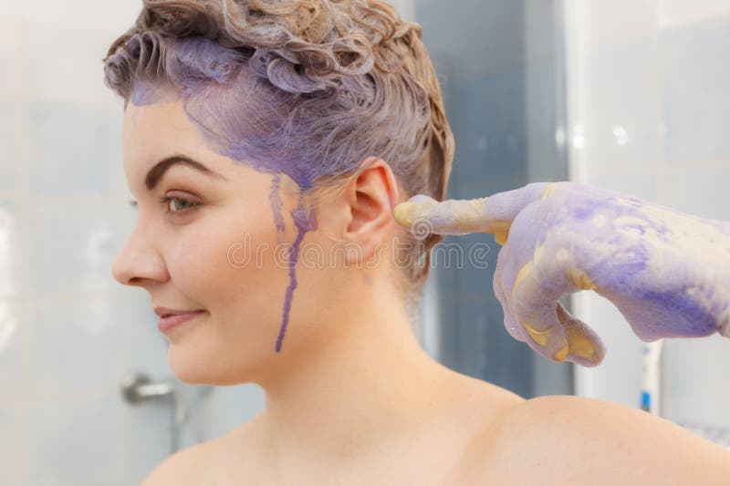 Mulher aplicando xampu de toner no cabelo fotografia de stock