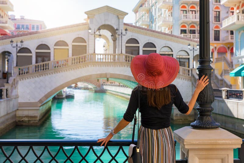 A mulher aprecia a vista ao Qanat Quartier na pérola em Doha foto de stock A mulher aprecia a vista ao Qanat Quartier na pérola em Doha foto de stock