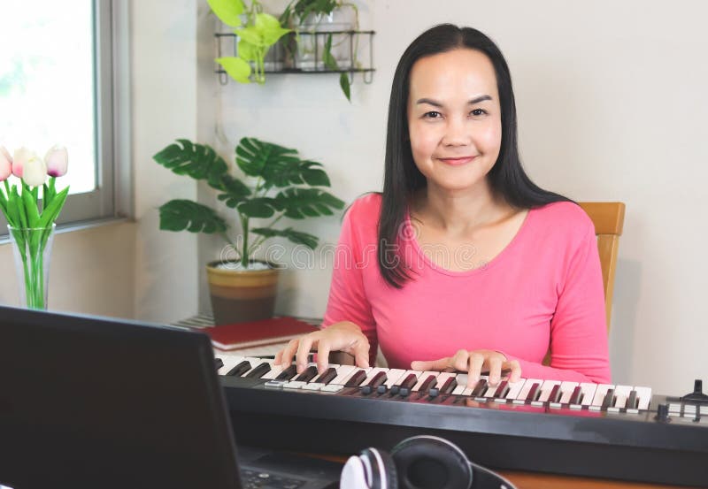 Linda garota asiática aprendendo música de piano online com